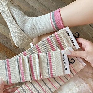 Detail view of ivory mid-calf socks with pink stripes and heart-shaped jacquard textures