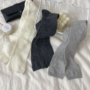 Detailed knit texture of calf-high slouch socks in grey, white and charcoal colors