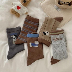 Flat lay of five pairs of vintage brown striped socks with cute dog and bear embroidery