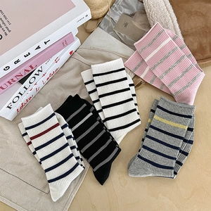 Vue à plat de cinq paires de chaussettes rayées mi-mollet aux couleurs variées et côtelées