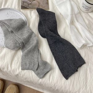 Detailed view of three pairs of ribbed knit calf socks in grey and white tones