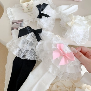 Close-up of Lolita style socks featuring layered white lace ruffles and large silk bows