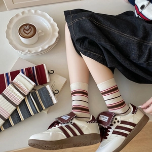 Retro red and blue striped mid-calf socks paired with white fashion sports sneakers