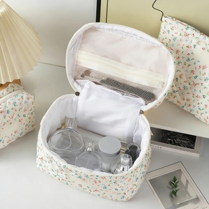 Internal view of floral quilted toiletry bag showing large capacity and mesh zipper pocket