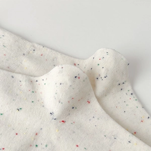 Macro shot of white confetti nep yarn socks with colorful speckles and knit texture