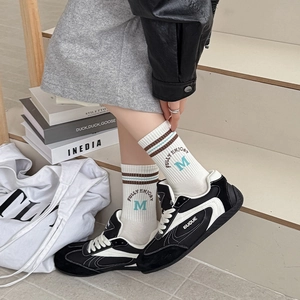 Retro style striped crew socks with M embroidery shown in a lifestyle college setting