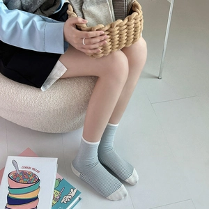 Detailed close-up of light blue and white striped crew socks with contrast heel and toe