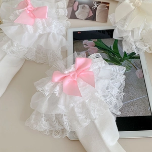 Detail of white Lolita socks with layered lace ruffles and pink satin ribbons