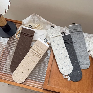 Detailed flat lay of five floral embroidered crew socks in earthy vintage tones