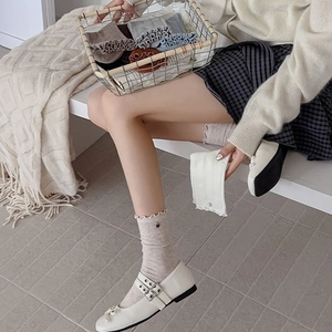 Nahaufnahme der Vintage-Socken mit Rüschensaum, Metallknöpfen und Rippenstrick-Details