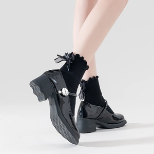 Detail of black patent leather Mary Jane shoes with buckle and Lolita ruffle socks