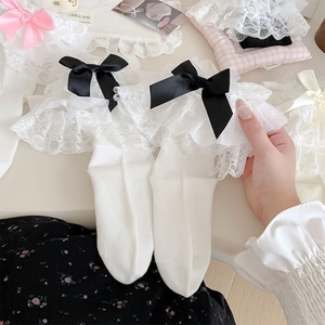 Detailed view of white Lolita socks featuring layered lace frills and a pink satin bow