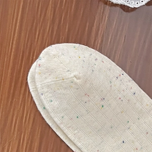 Detailed macro view of cream knit socks with colorful nep yarn and ribbed texture details