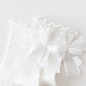 Detail of white Lolita socks featuring ruffled lace edges and sheer organza bows