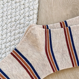 Detail of knit cotton texture and colorful stripes on orange crew socks for women