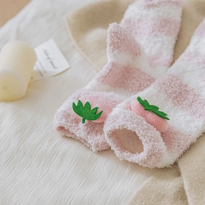 Detail of coral fleece socks with pink stripes and 3D strawberry plush decoration