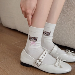 Close-up of white cotton socks featuring cute cat embroidery and pink plaid bow detail