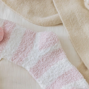 Close-up of pink striped coral fleece socks with cute 3D strawberry plush detail