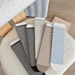 Detail view of five pairs of striped cotton crew socks in neutral milk tea color tones