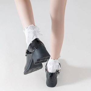 Detail of black patent leather Mary Janes with white ruffle bow knee high socks