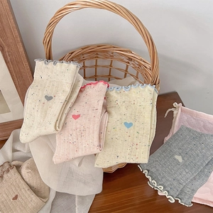 Detail of sweet heart pattern socks with ruffle trim in various pastel knit colors