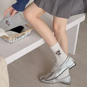 Detailed embroidery of cat face with blue bow on white and grey cotton socks