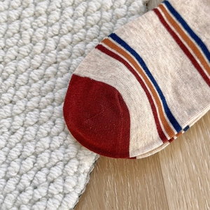 Close-up of knit fabric on colorful striped socks with detailed toe stitching