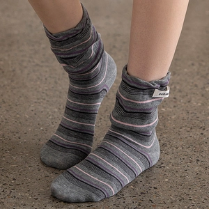 Detail of grey striped slouch socks featuring a logo patch and ribbed texture