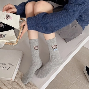 Close-up of gray knit socks featuring embroidered cat pattern and blue 3D bow detail