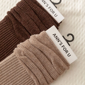 Detailed close-up of dark brown and khaki ribbed knit socks with brand hangtags