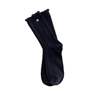 Black knit mid-calf socks with ruffle trim and decorative button in a vintage style