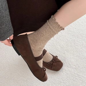 Brown suede Mary Jane flats with bow detail paired with ruffled knit socks in forest style