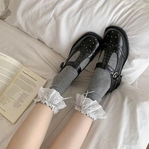 Black Mary Jane shoes with T-strap and lace trim socks on a white background
