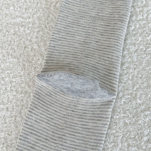 Macro shot of striped knit socks showing detailed heel stitching and thick grey fabric