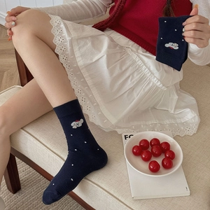 Dettaglio calzini blu navy con pois bianchi e ricamo di un simpatico cucciolo ricamato