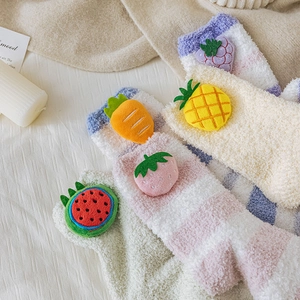 Detail of soft coral fleece socks with 3D cute fruit dolls and colorful striped patterns
