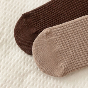Close-up of brown ribbed cotton socks showing fine vertical texture and soft knit detail