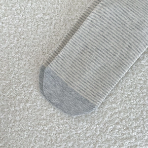 Macro shot of reinforced toe detail on gray and white striped knit cotton crew socks