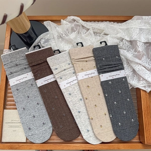Detail of five pairs of floral knit cotton socks in vintage autumn colors with rib cuffs