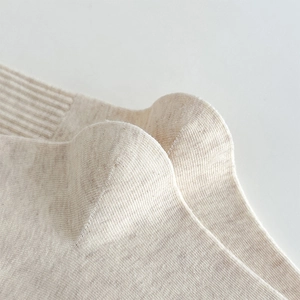 Detailed macro view of beige ruffle socks showing the fine rib knit and curved heel texture