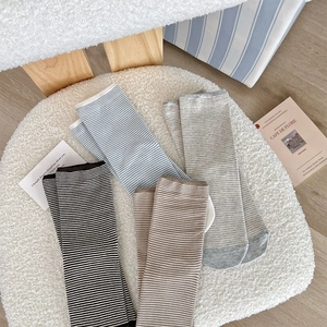 Detail of four-color striped crew socks set in soft knit texture on white fleece