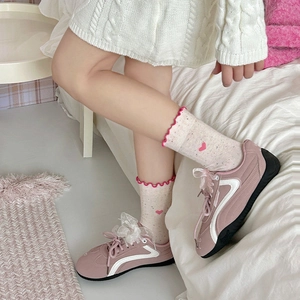 Pink sneakers with sheer bow laces and beige heart pattern socks with ruffled edges