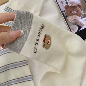 Detail of striped cotton sock featuring a cute bear patch and CUTE BEAR embroidery