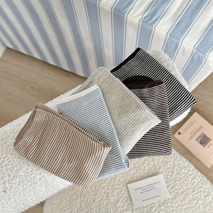 Detail of striped cotton socks in assorted neutral tones on textured background