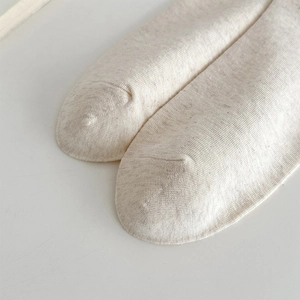 Detail of seamless toe stitching on cream knitted lace socks with fine ribbed texture