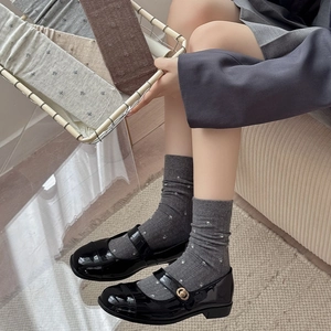 Detailed knit texture of vintage floral crew socks in grey, beige and brown cotton