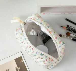Detailed view of floral quilted makeup bag with internal cosmetic bottles and soft padding