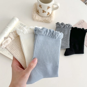 Detail view of cotton blend crew socks featuring ruffled lace edges and vertical ribbed texture