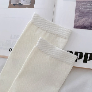 Detail of ribbed cuffs on white mid-calf socks with high-quality cotton knit texture