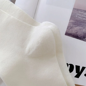 Close-up of white knit cotton sock showing detailed heel structure and fine texture